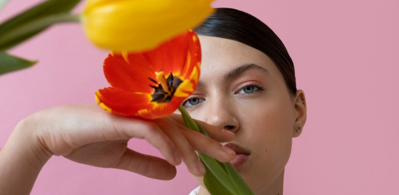 girl posing with two spring tulips in front of her face